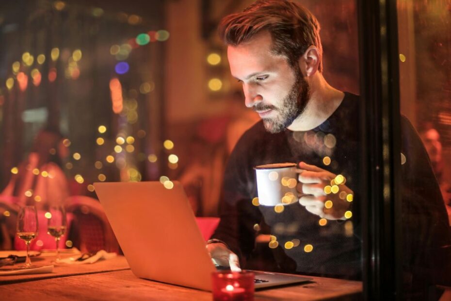 Imagem de homem mexendo no notebook para ilustrar conteúdo sobre os benefícios da legendagem em seus vídeos.
